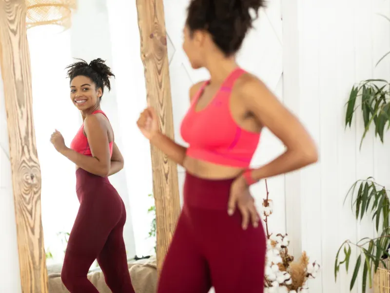 Woman looking fit in a mirror.